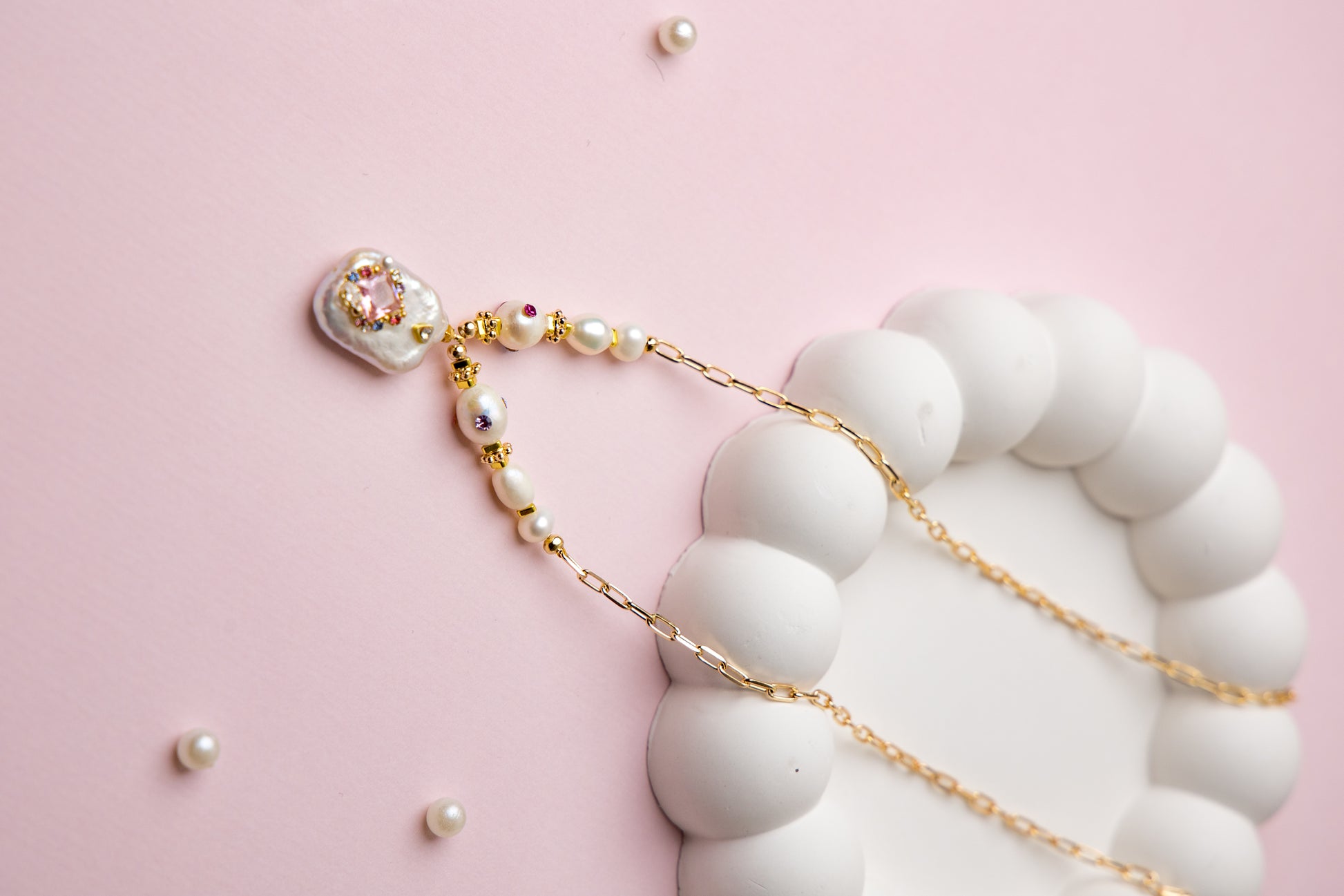 A bold necklace with large baroque seawater pearls and a central floral design, connected by a textured gold chain. Ideal for statement looks.