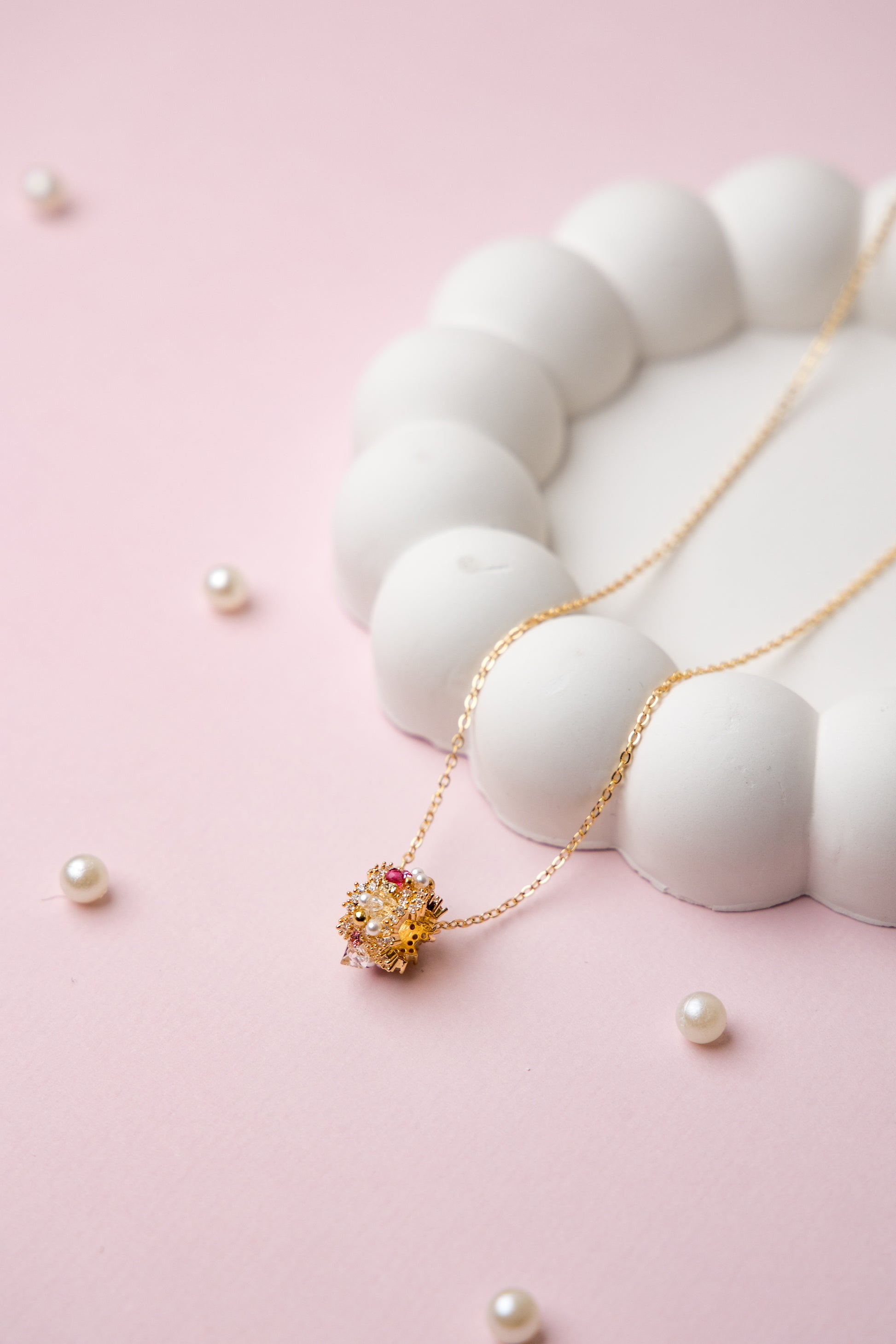 A gold-tone chain necklace with a central floral bead cluster, featuring crystals and delicate craftsmanship.