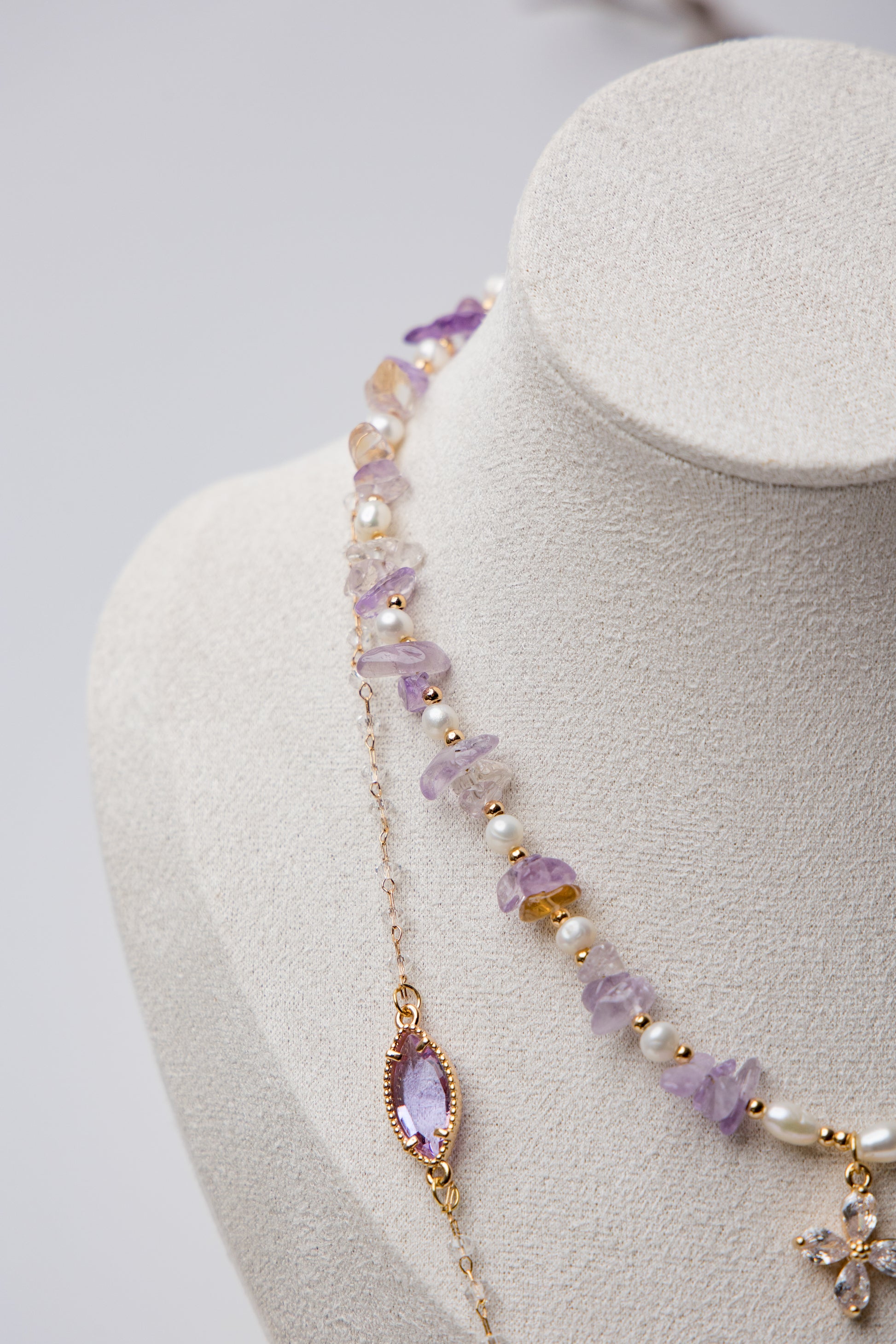 Three-tier necklace set with lavender amethyst stones, pearls, and a central floral crystal. A perfect mix of boho and elegance.