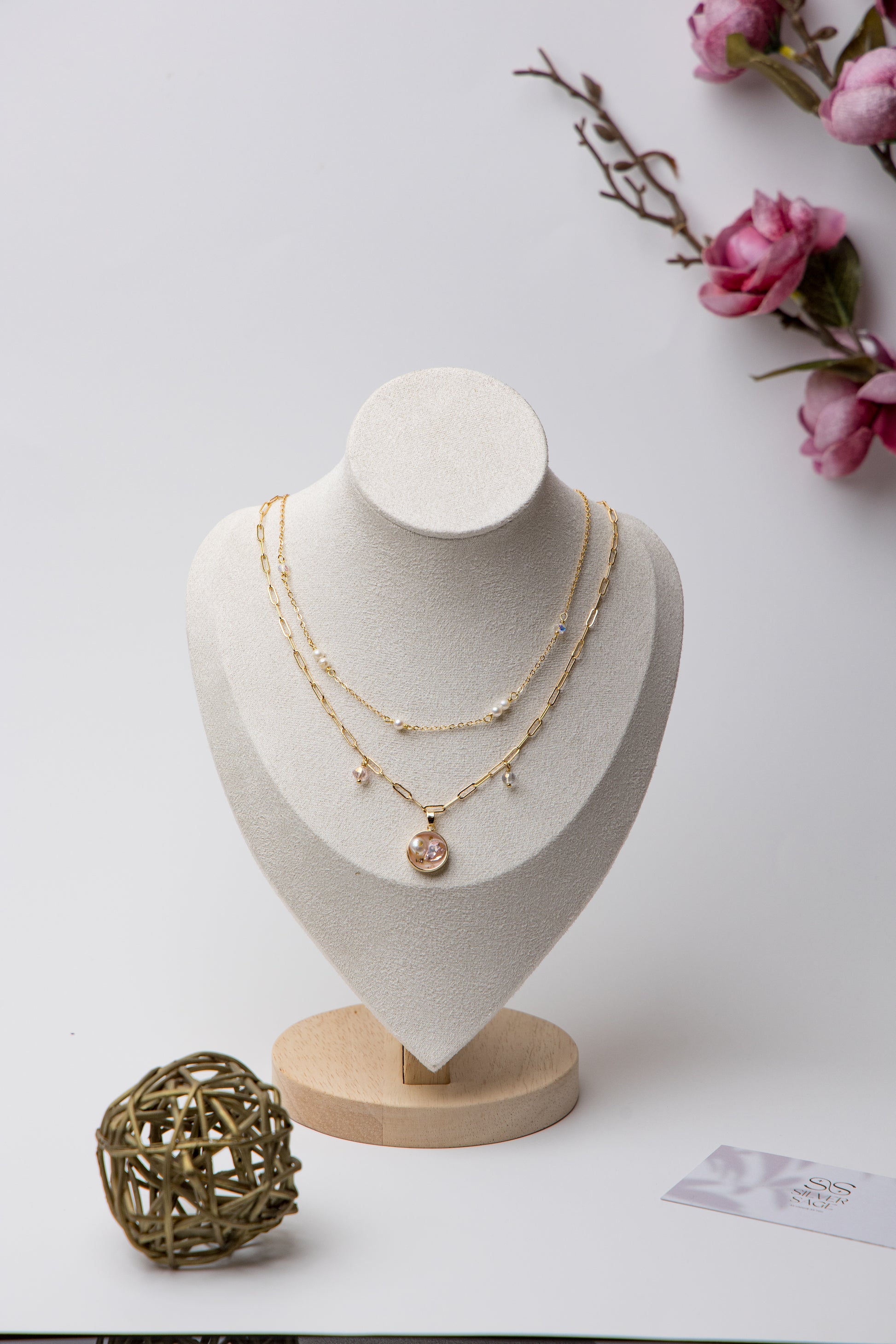 A delicate gold-layered necklace with soft pink crystals and dainty pearls.
