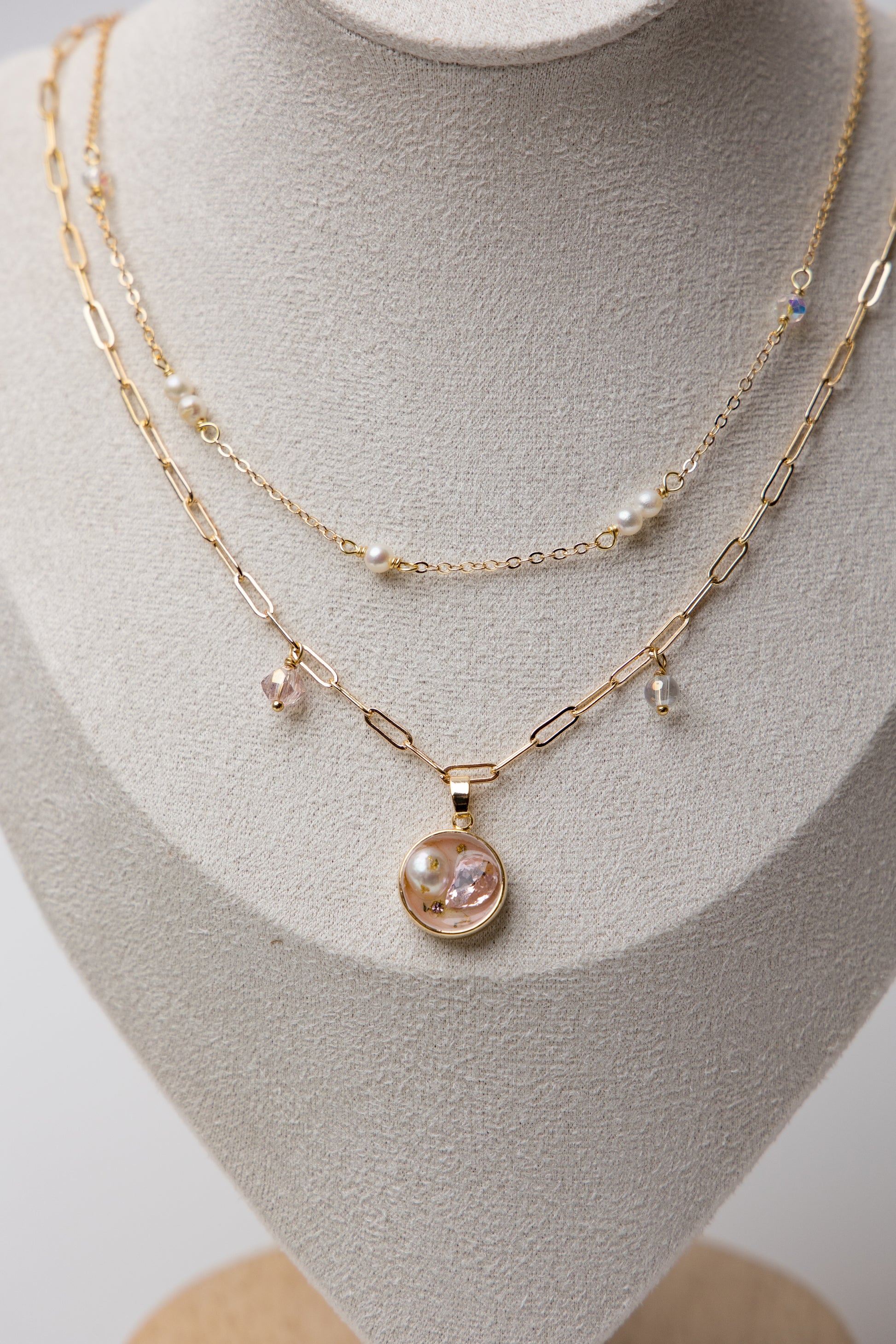 A delicate gold-layered necklace with soft pink crystals and dainty pearls.