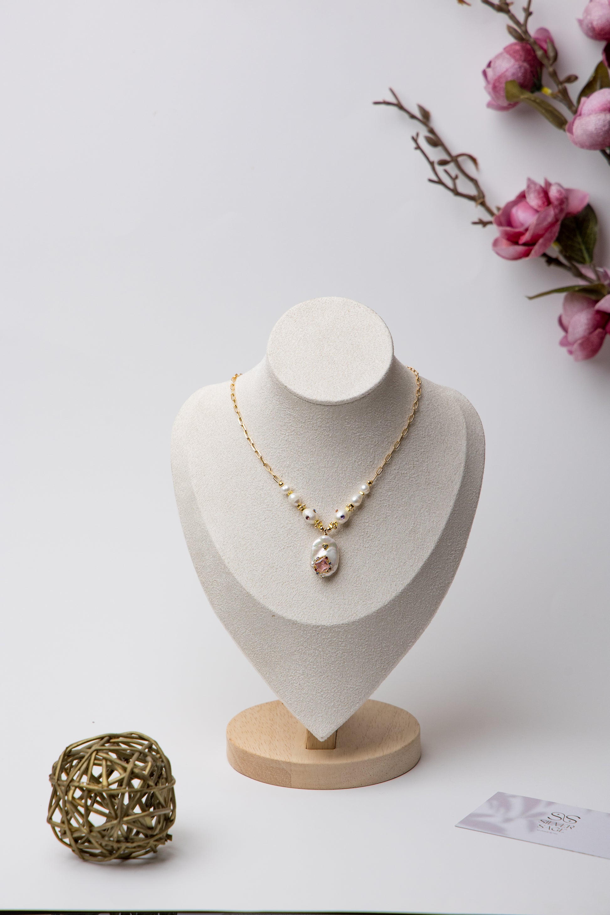 A bold necklace with large baroque seawater pearls and a central floral design, connected by a textured gold chain. Ideal for statement looks.