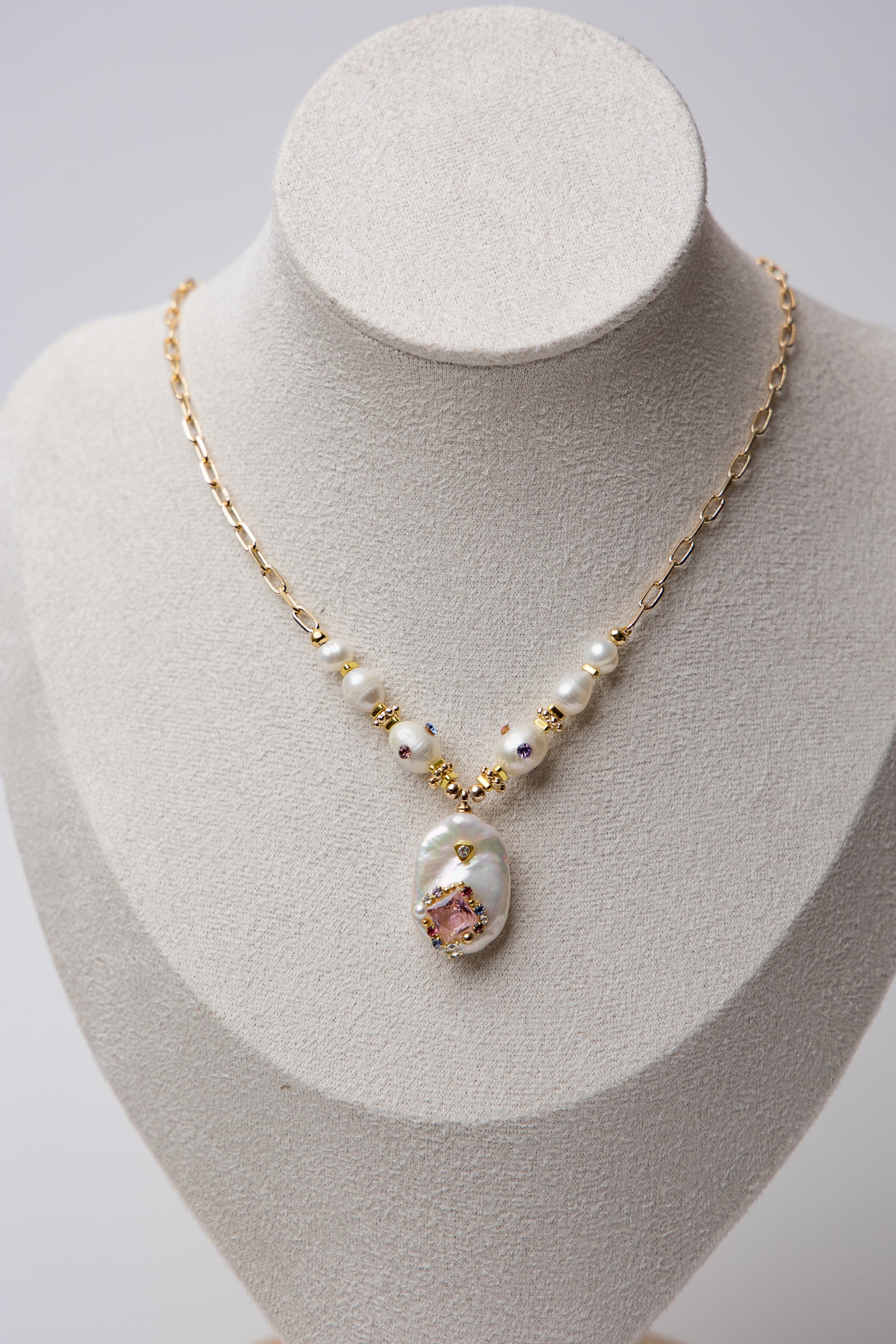 A bold necklace with large baroque seawater pearls and a central floral design, connected by a textured gold chain. Ideal for statement looks.