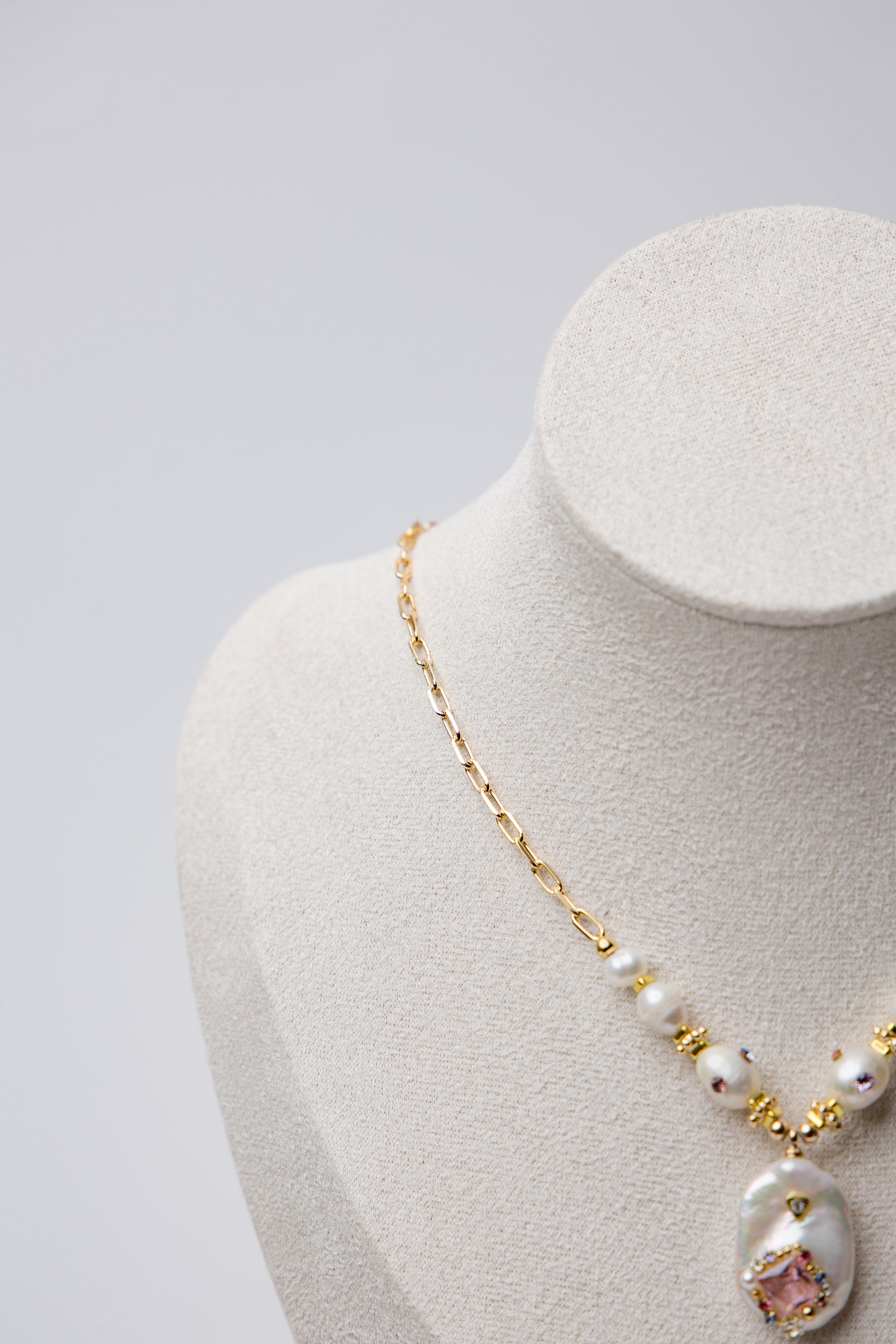 A bold necklace with large baroque seawater pearls and a central floral design, connected by a textured gold chain. Ideal for statement looks.