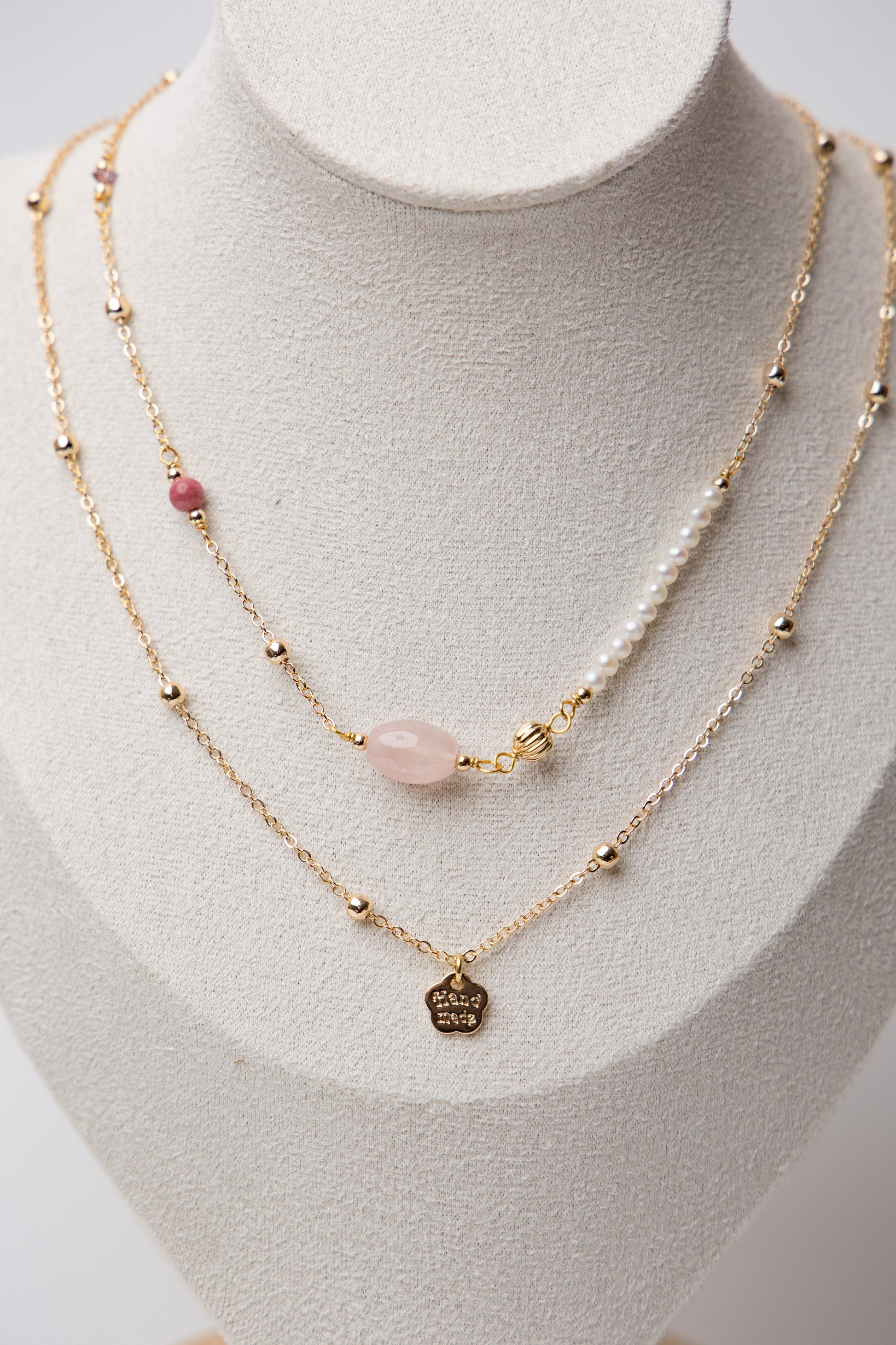 An elegant layered piece featuring a moonstone centerpiece with mixed textures and beadwork, blending classic and modern styles.
