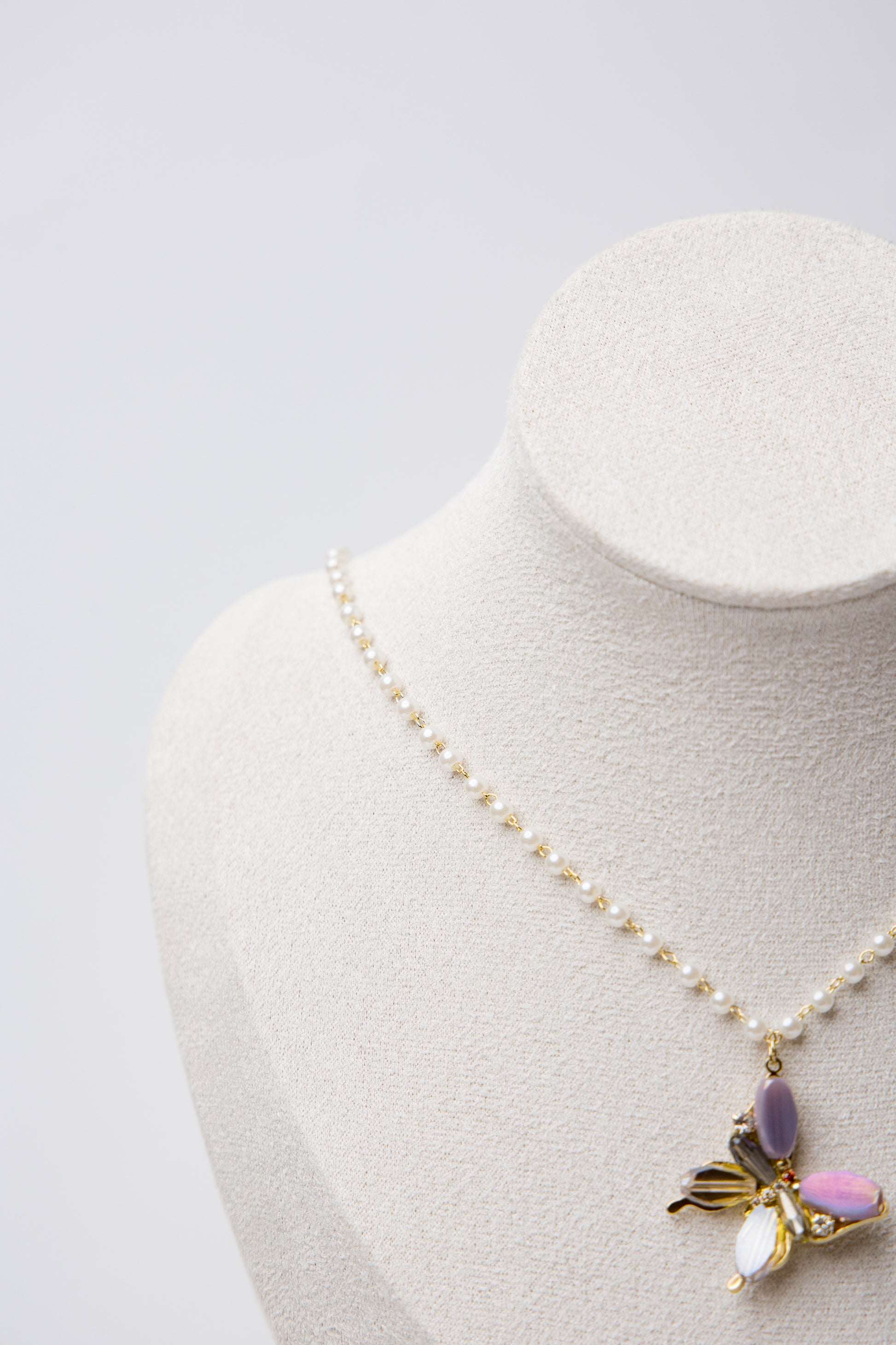 A pearl-linked necklace featuring a multicolor butterfly pendant with luminous luxe appeal.