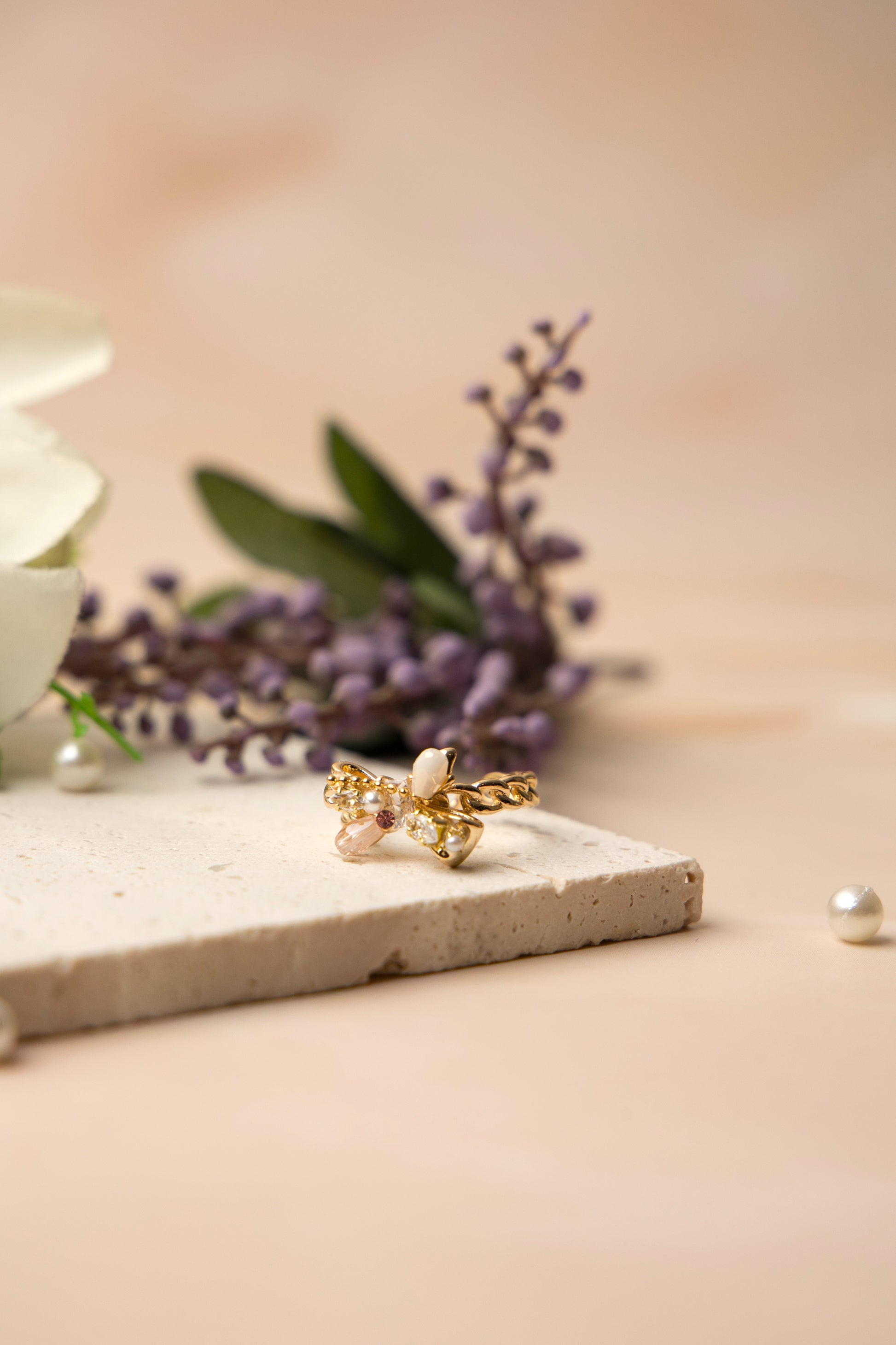 The Aurora Bow Ring is lavishly adorned with lustrous pearls and hand-set crystals in varying cuts and tones.