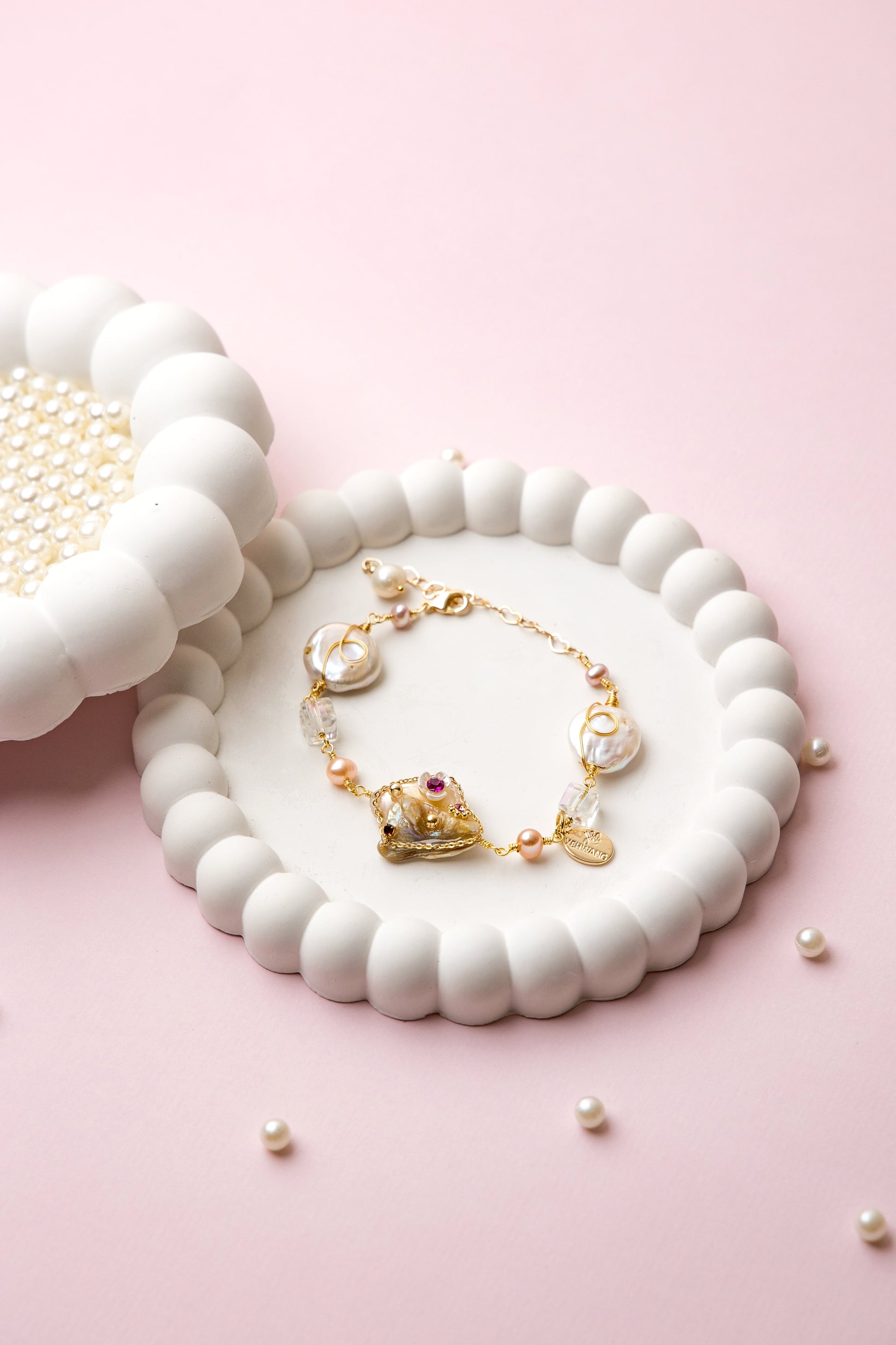 "Royal Whimsy Pearl Bracelet with a crown-inspired gold centerpiece, soft pink pearls, and crystal accents, blending vintage charm with modern elegance."