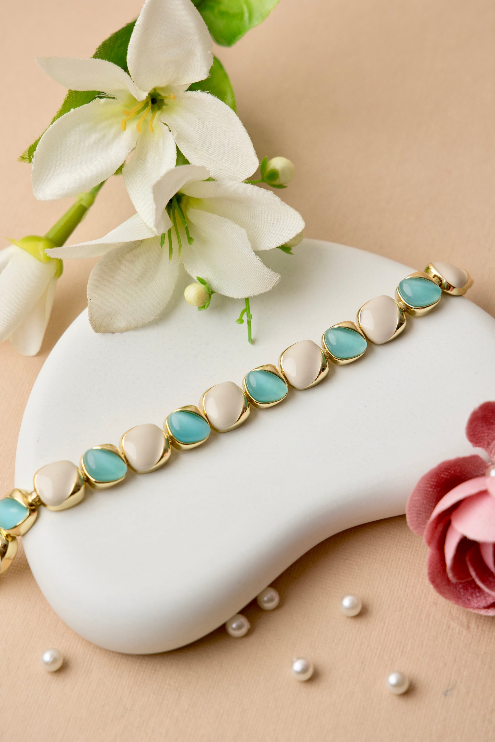 "Ocean Pearl bracelet with soft teal and ivory enamel ovals in a gold finish, offering a refined, feminine look inspired by the sea."