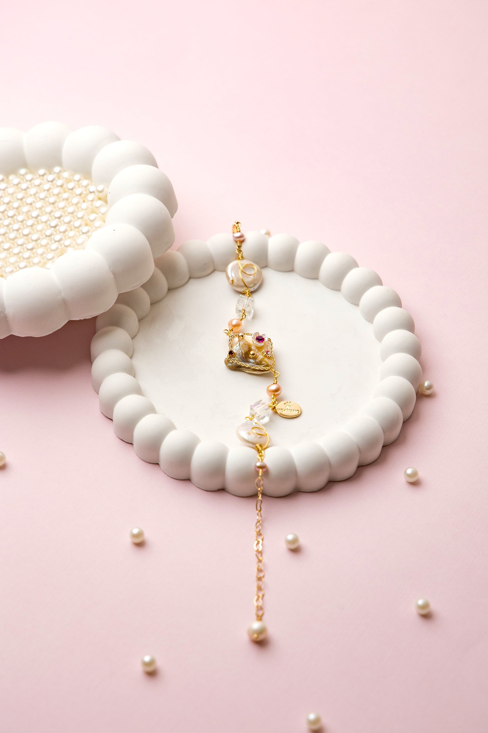 "Royal Whimsy Pearl Bracelet with a crown-inspired gold centerpiece, soft pink pearls, and crystal accents, blending vintage charm with modern elegance."
