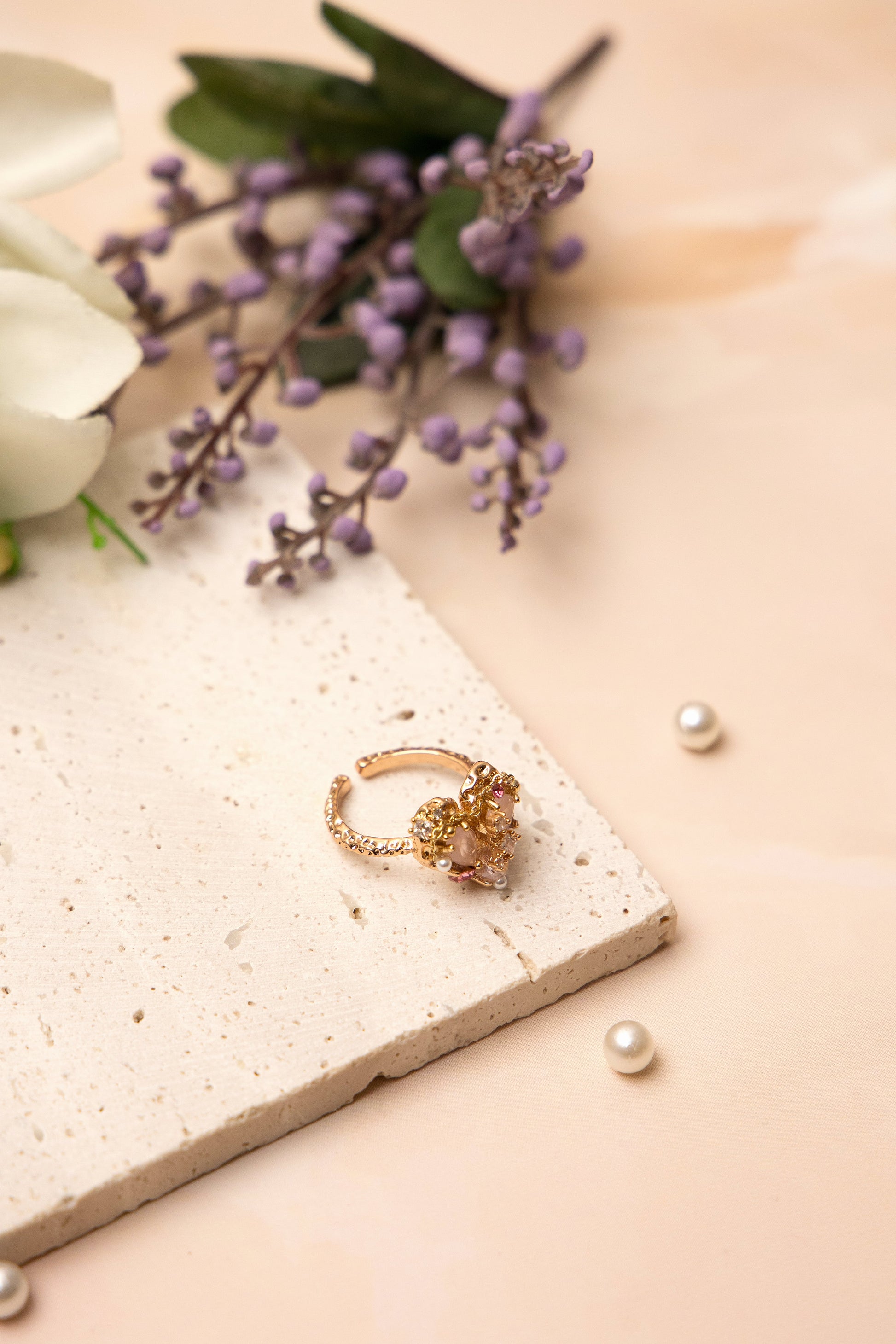 The Rosalind Heart Ring is crafted around a blushing heart-shaped crystal, encircled by dainty pearls and delicate stones.