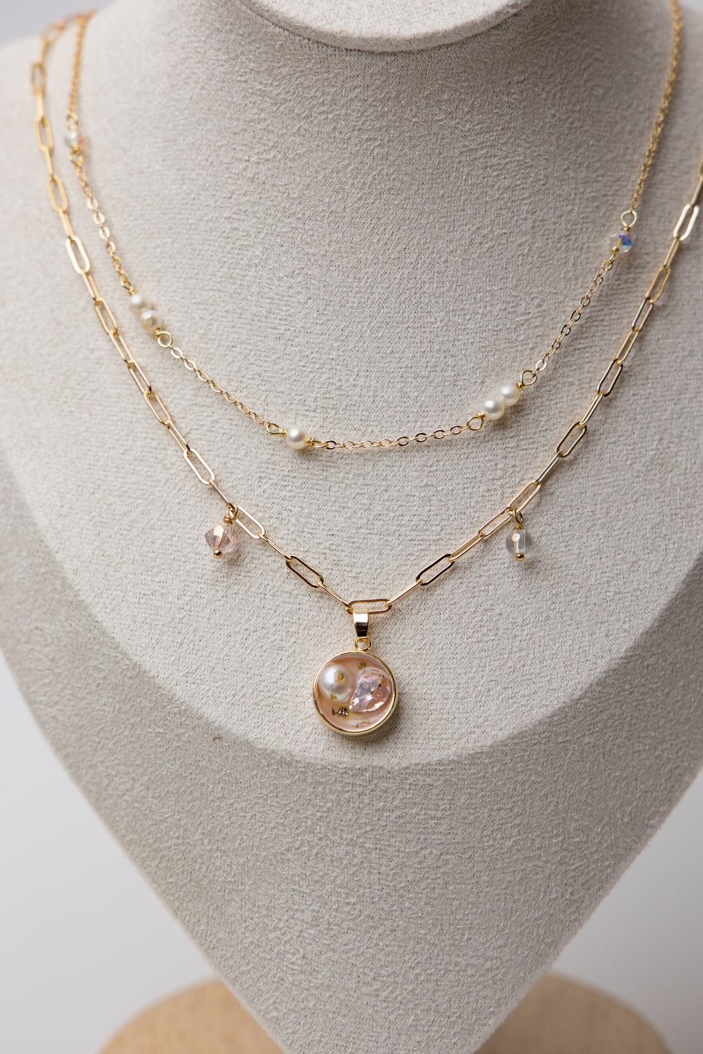 A delicate gold-layered necklace with soft pink crystals and dainty pearls.