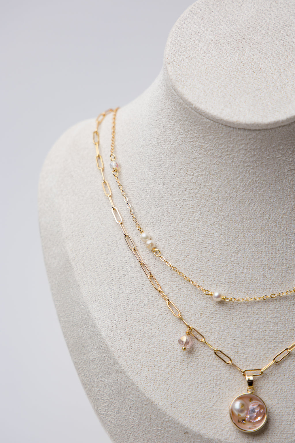 A delicate gold-layered necklace with soft pink crystals and dainty pearls.