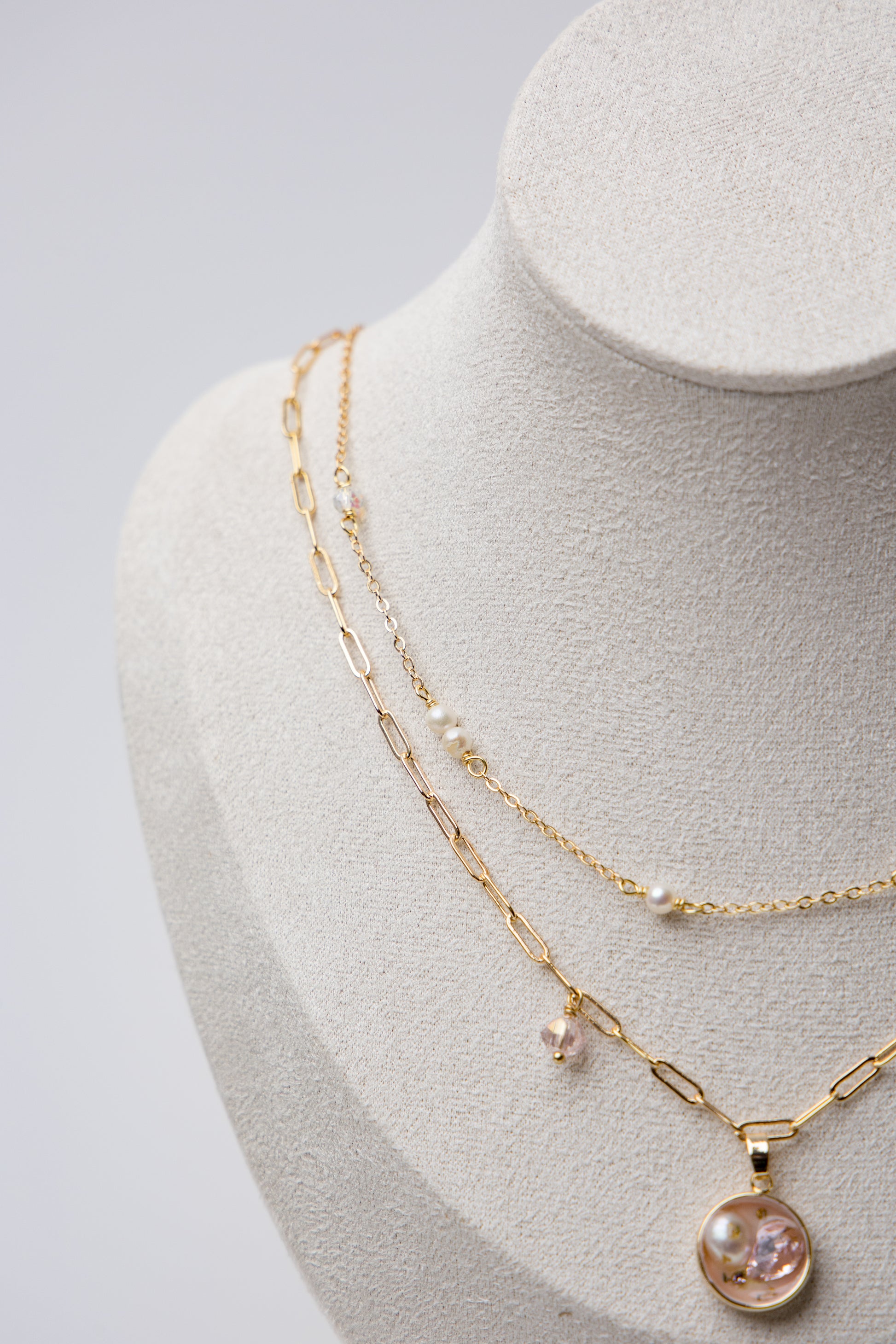 A delicate gold-layered necklace with soft pink crystals and dainty pearls.