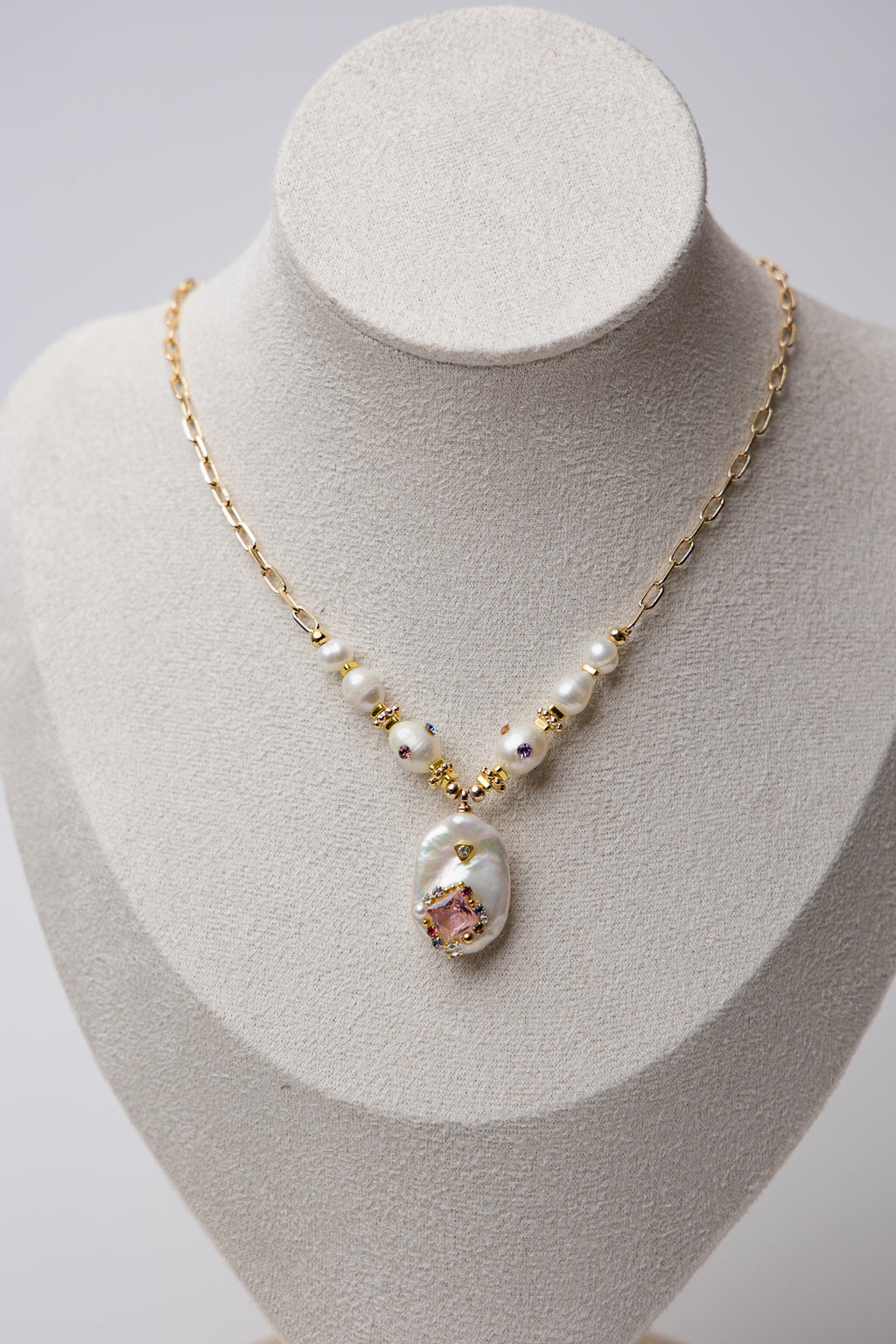 A bold necklace with large baroque seawater pearls and a central floral design, connected by a textured gold chain. Ideal for statement looks.