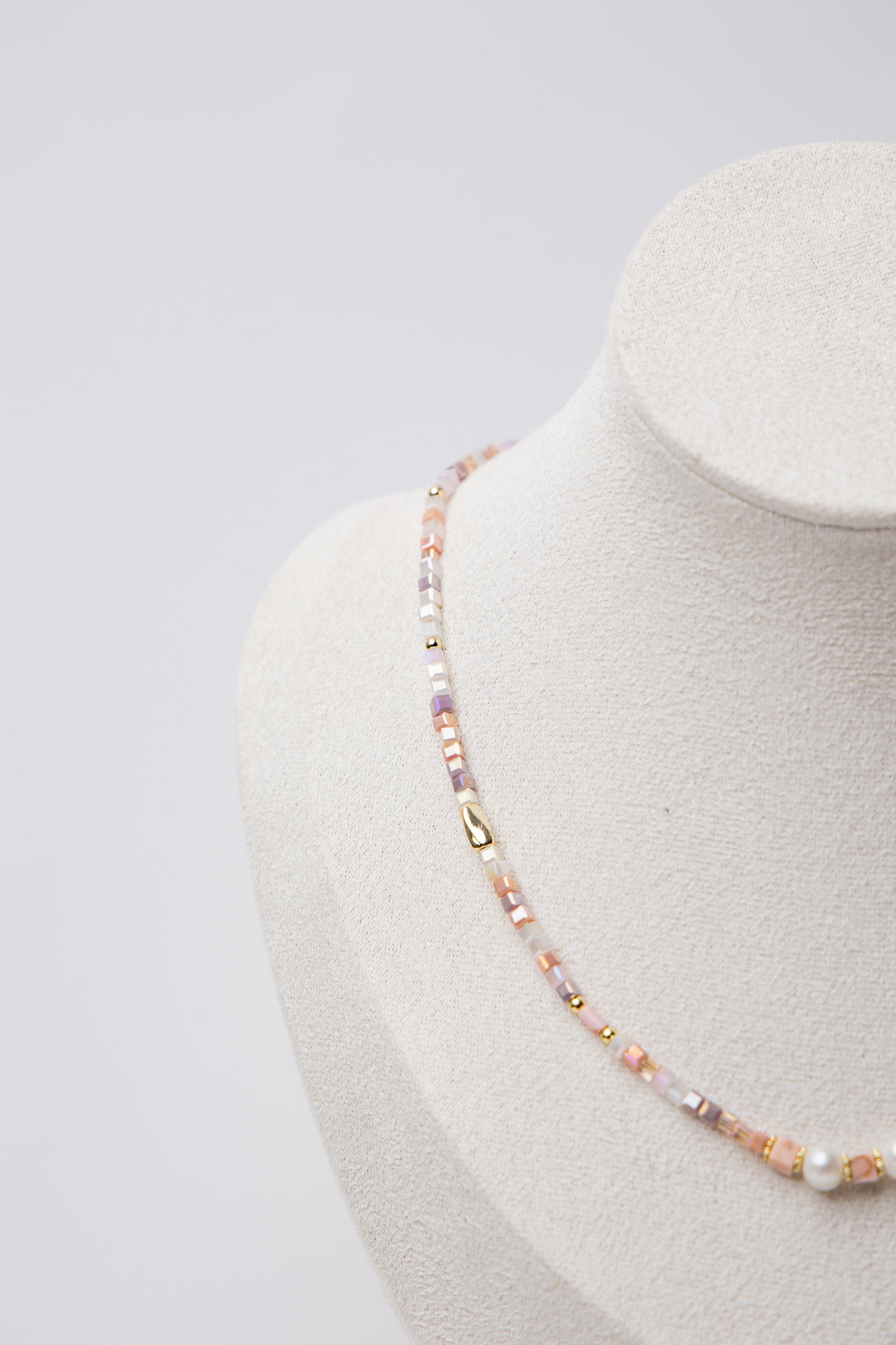 Pearl Glow Beaded Necklace in Blush Pink with pastel pink cube beads, luminous freshwater pearls, and gold accents, offering a soft and elegant statement piece.