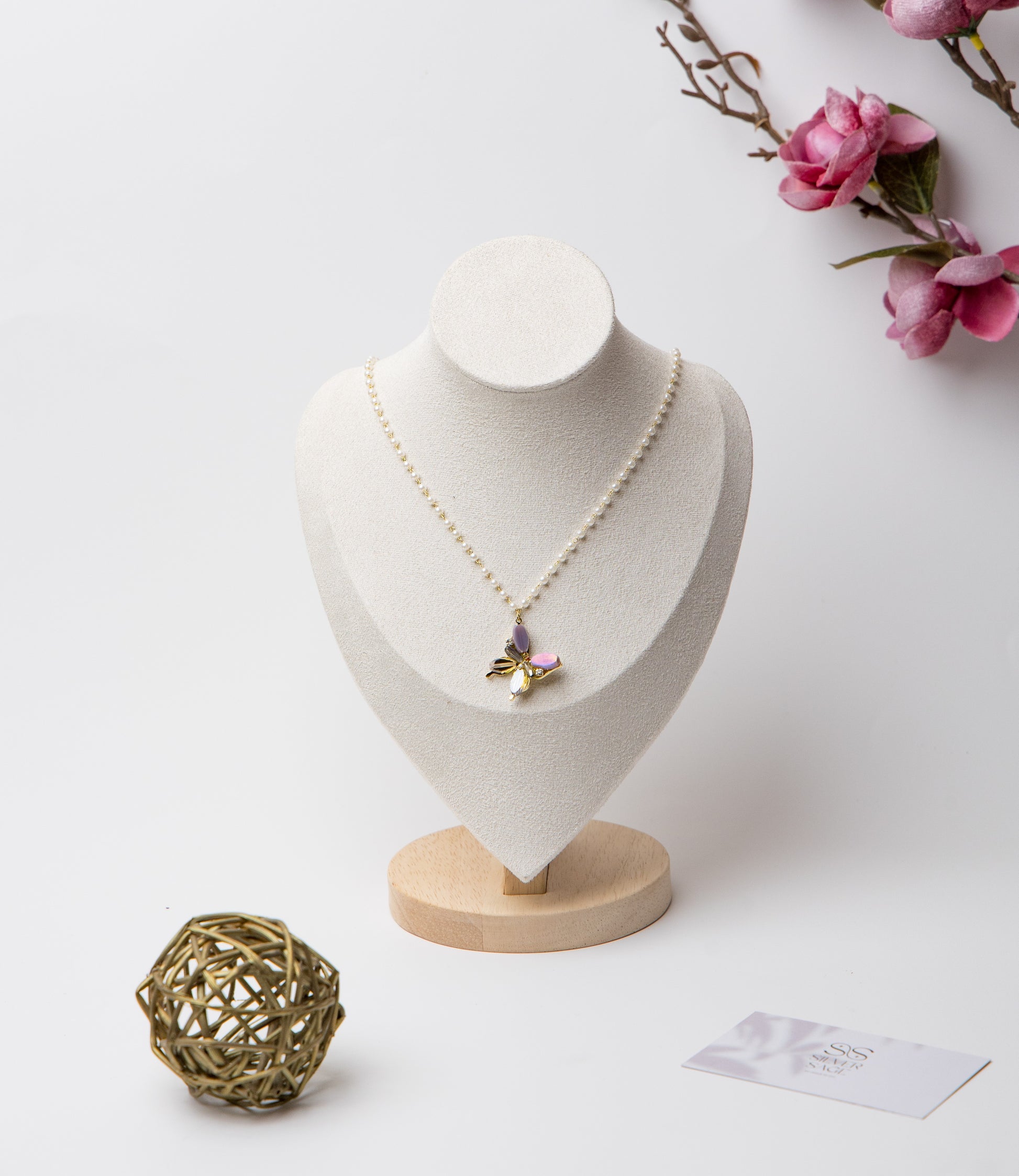 A pearl-linked necklace featuring a multicolor butterfly pendant with luminous luxe appeal.