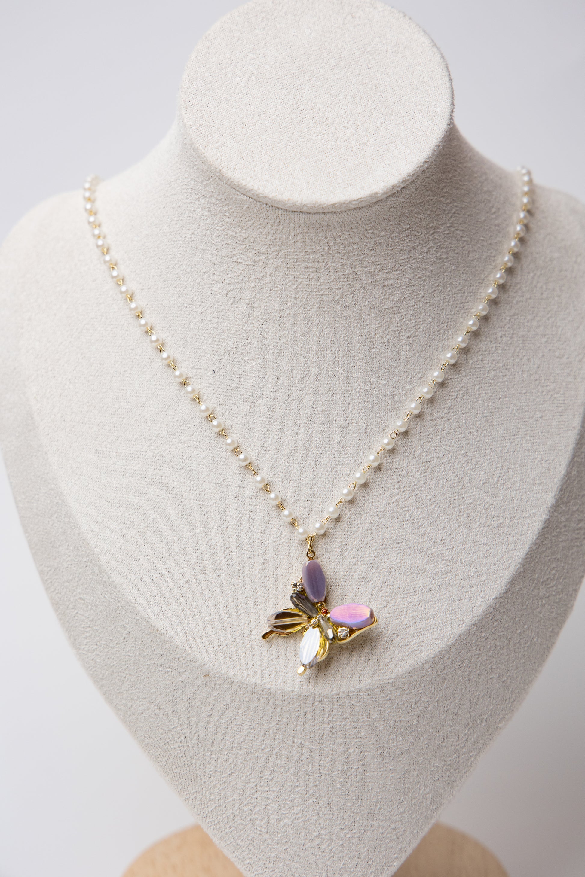 A pearl-linked necklace featuring a multicolor butterfly pendant with luminous luxe appeal.