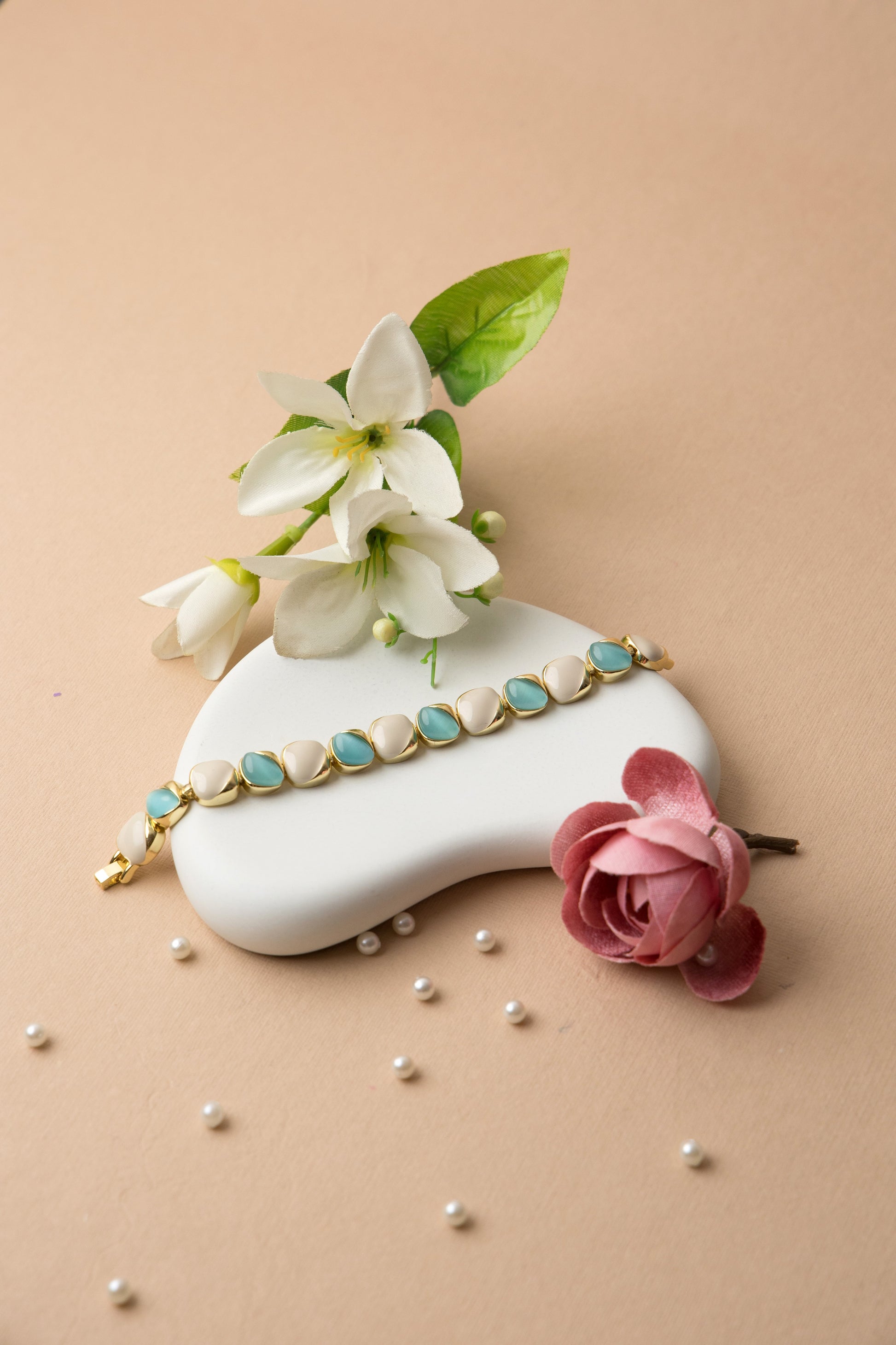 "Ocean Pearl bracelet with soft teal and ivory enamel ovals in a gold finish, offering a refined, feminine look inspired by the sea."
