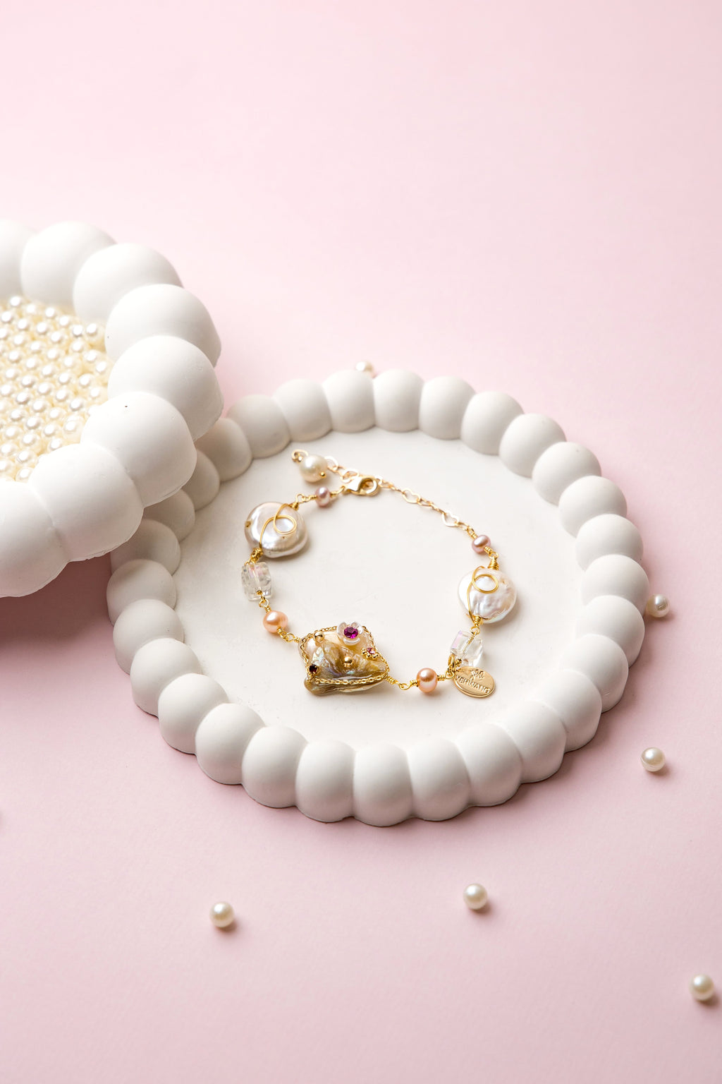 "Royal Whimsy Pearl Bracelet with a crown-inspired gold centerpiece, soft pink pearls, and crystal accents, blending vintage charm with modern elegance."