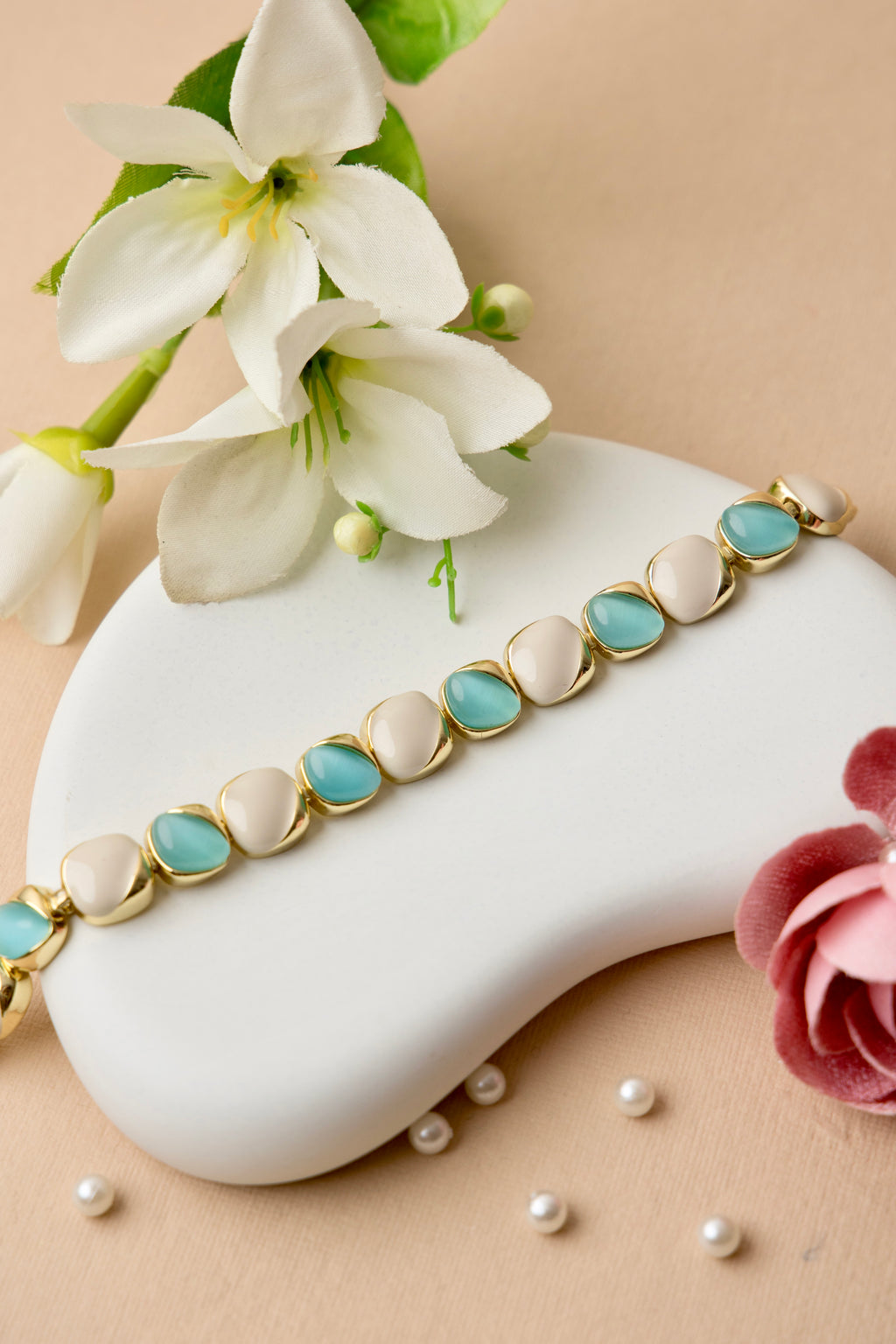 "Ocean Pearl bracelet with soft teal and ivory enamel ovals in a gold finish, offering a refined, feminine look inspired by the sea."